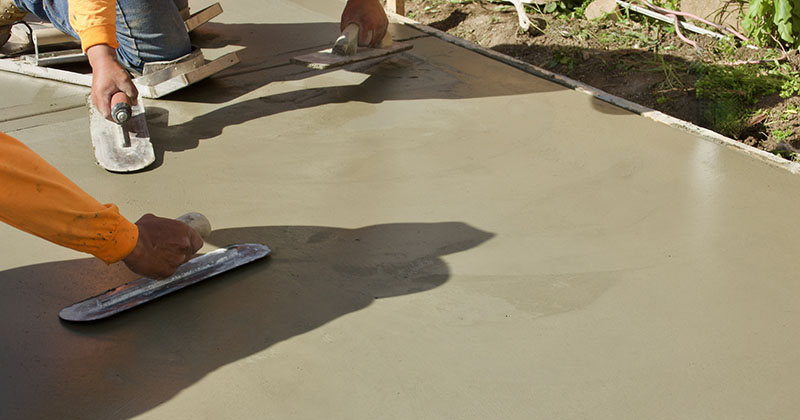 Två personer arbetar med betong